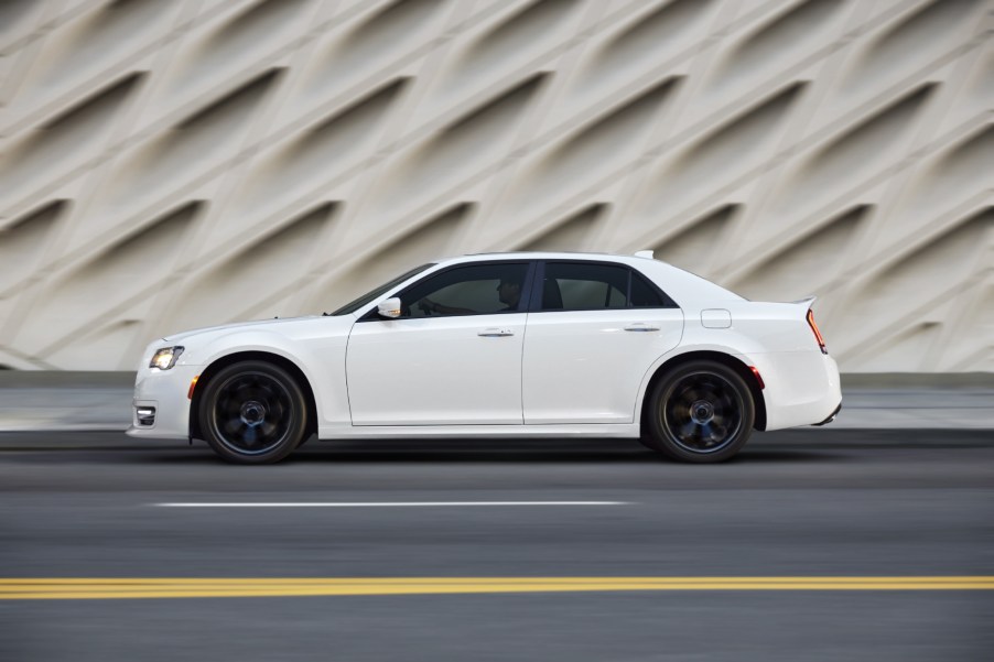 A white 2021 Chrysler 300 on display next to a fancy white wall