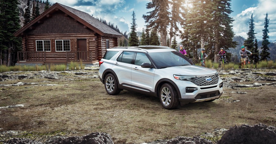 A white 2021 Ford Explorer parked on display in front of a country house.