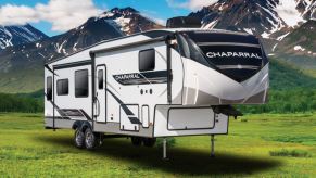 A 2021 Forest River Chaparral Fifth-Wheel RV Trailer sits at the base of a mountainside.