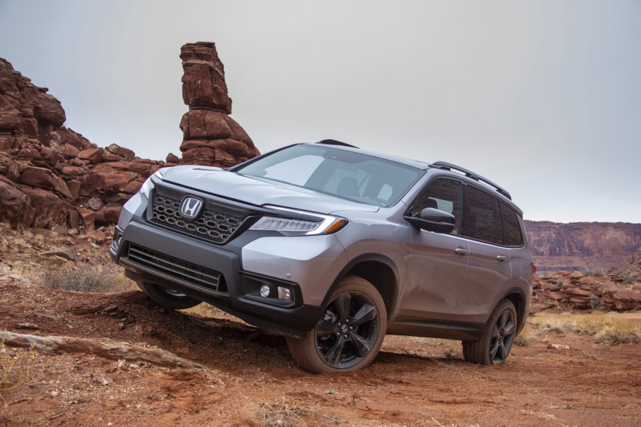 A silver 2021 Honda Passport driving over rugged terrain