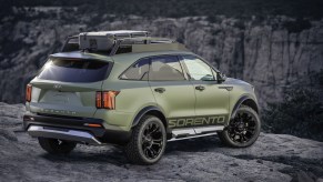 An olive-green 2021 Kia Sorento Yosemite overlooks a canyon on mountainous terrain