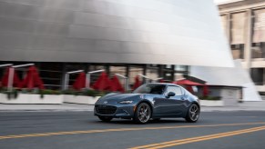 A blue 2021 Mazda MX-5 Miata RF driving down a road