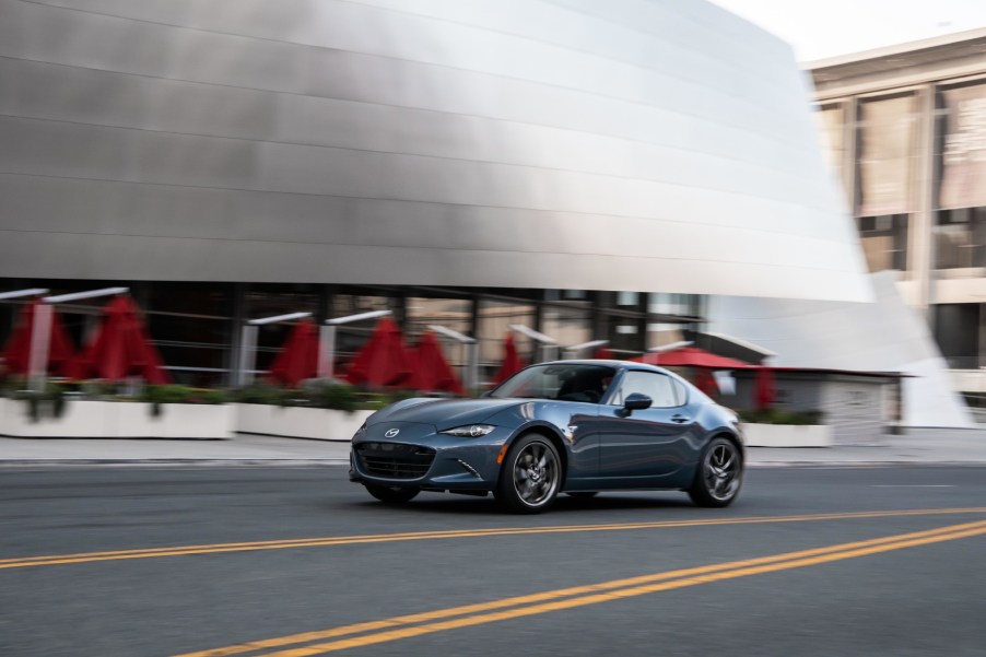 A blue 2021 Mazda MX-5 Miata RF driving down a road