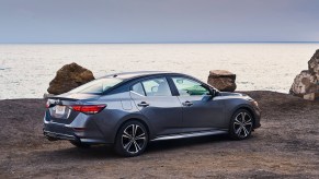 A 2021 Nissan Sentra in Gun Metallic is parked overlooking an ocean.