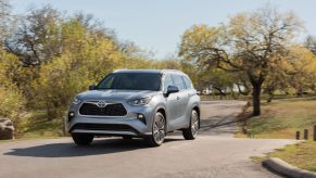 A silver 2021 Toyota Highlander parked between two trees