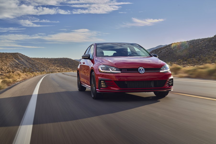 A red 2021 Volkswagen Golf GTI driving down a highway