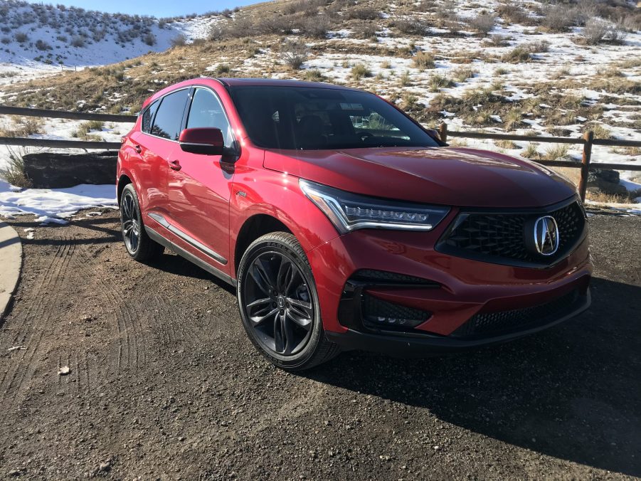 A red Acura RDX parked curbside.