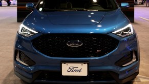 A blue Ford Edge on display at an auto show