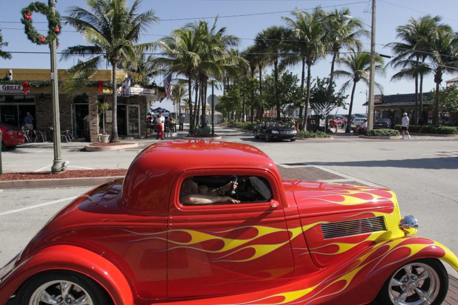 A red hot rod with yellow flames painted on.