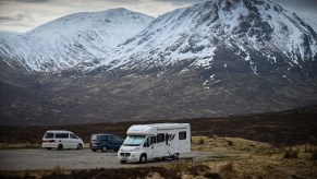 A Class C RV is parked in a car park as members of the public are asked to stop traveling to the Scottish Highlands