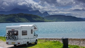 An RV camper parked on the shore along Kyle of Tongue, shallow sea loch in northwest Highland, Sutherland, Scottish Highlands, Scotland, UK.