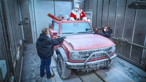 Santa stands in the back of the 2021 Ford Bronco's discussing cold weather testing results with two engineers | Ford Motor Company