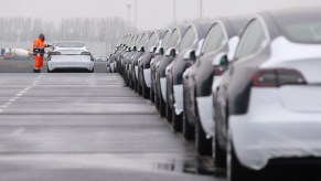 A worker checks a Tesla Model 3 vehicle after driving it out of a vessel at Zeebrugge port, Belgium