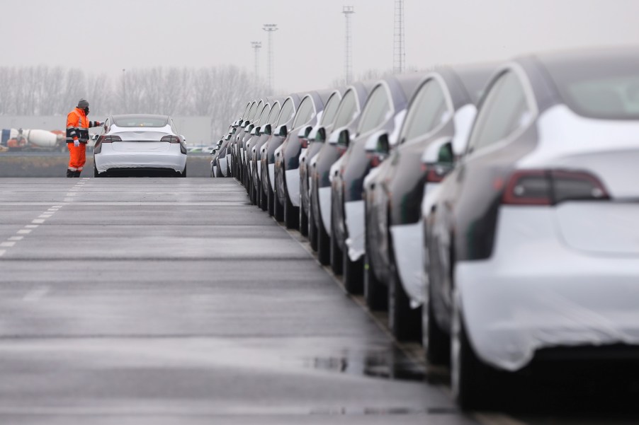 A worker checks a Tesla Model 3 vehicle after driving it out of a vessel at Zeebrugge port, Belgium