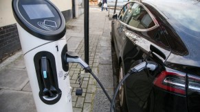 A Tesla car uses an electric vehicle charging station in London.