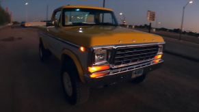 The front passenger side of a yellow and white 1979 Ford F-150 Raptor restomod by Sweet Brothers