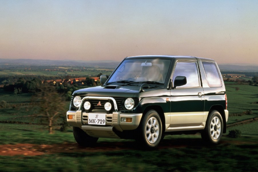 A dark-green 1994 Mitsubishi Pajero Mini on a grassy hill