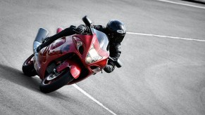 A black-clad rider taking a corner on a red 2020 Suzuki Hayabusa