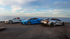 Three 2021 Chevy Corvette Stingray coupe and convertible models overlooking an ocean