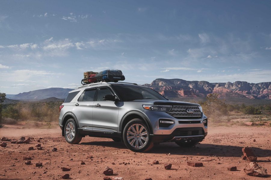 A silver 2021 Ford Explorer with a bag mounted on its roof rack driving down a dirt road