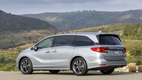 A silver 2021 Honda Odyssey parked on a road in front of mountains