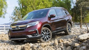 A dark red 2021 Honda Pilot parked on rocky terrain