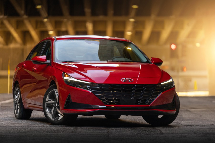 A red 2021 Hyundai Elantra sedan parked in a lit hangar