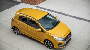 A 2021 Mitsubishi Mirage in Sand Yellow parked on a concrete slab