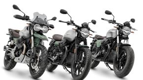 A silver-and-green liveried 2021 Moto Guzzi V85 TT Adventure 100th Anniversary next to a V7 Stone 100th Anniversary next to a V9 Bobber 100th Anniversary