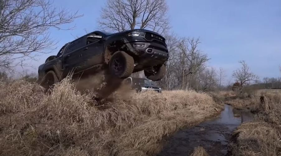 A black 2021 Ram 1500 TRX off-road pickup runs off the end of a ramp.