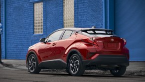 A red 2021 Toyota C-HR parked next to a blue wall