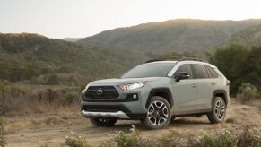 A green 2021 Toyota RAV4 parked with a mountain in the background