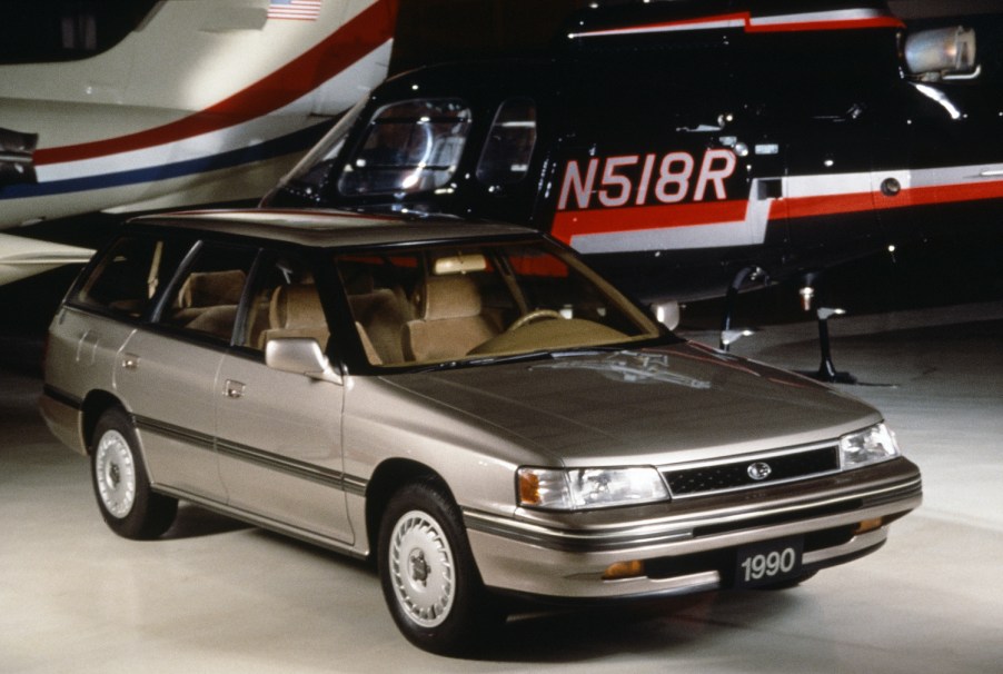 1990 Subaru Legacy wagon parked in front of a plane