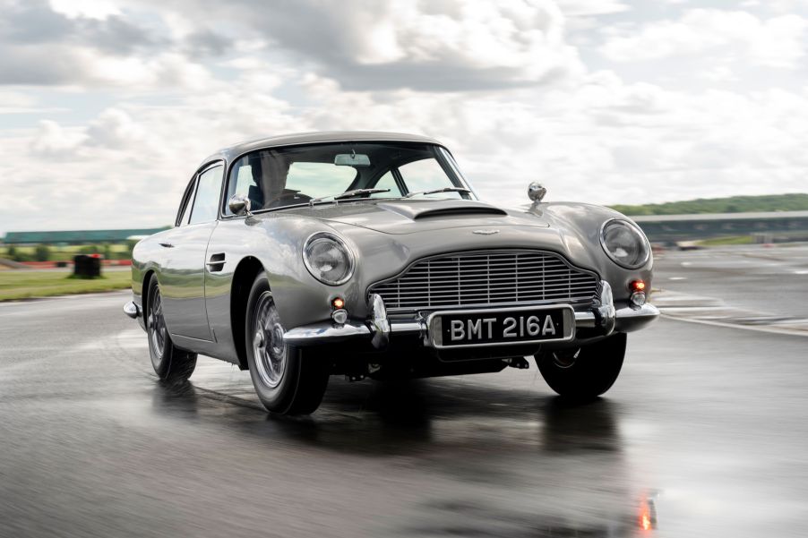 A silver Aston Martin DB5 Goldfinger Continuation on a wet track