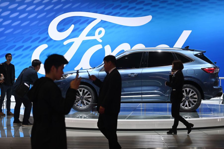 Visitor walk past a Ford Escape Titanium at the Shanghai Auto Show