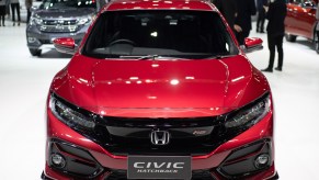 A red Honda Civic Hatchback on display at an auto show