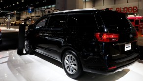 A black Kia Sedona on display at an auto show