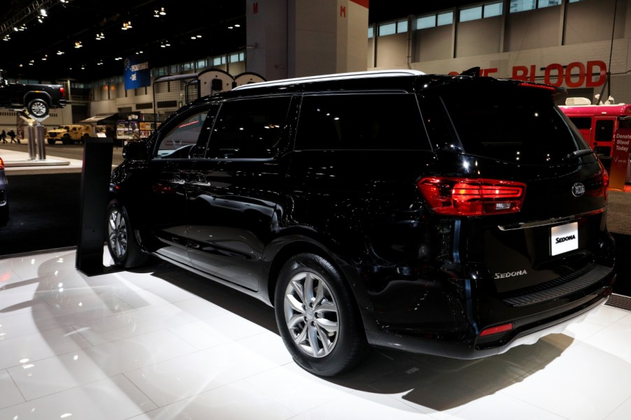 A black Kia Sedona on display at an auto show