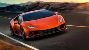 An orange Lamborghini Huracán EVO travels on a paved mountain road