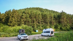 People camping in a 4x4 Toyota Landcriuser with a roof tent and Mercedes Sprinter James Cook edition RV camper van near the thermal lake Kalameny