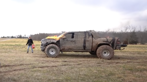 An image of a broken 2021 Ram 1500 TRX on enormous tires off-road.