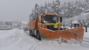 A snowplow clearing a snow-filled road