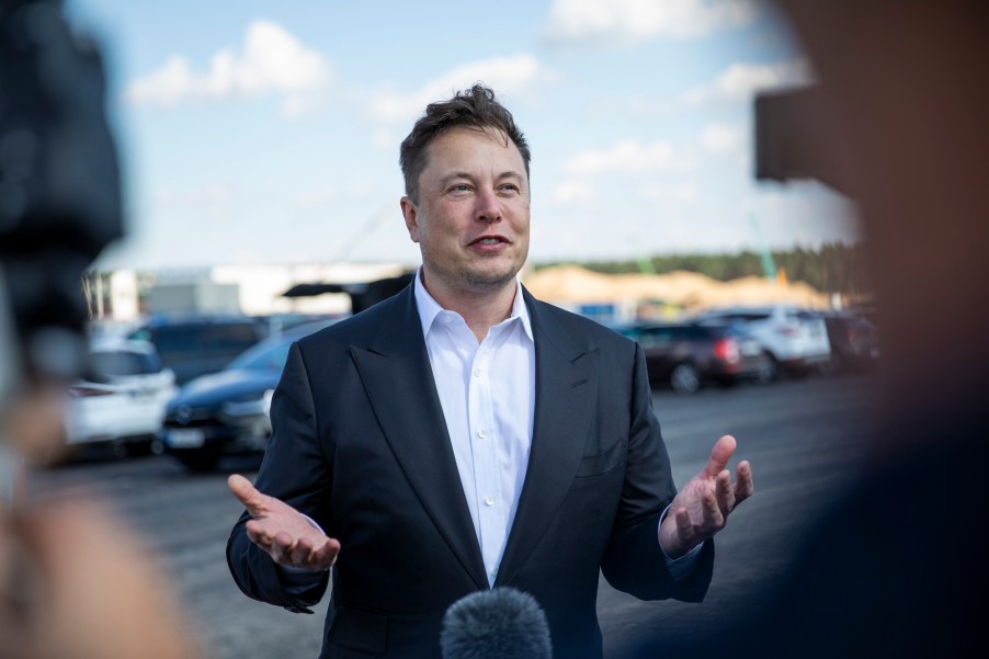 Tesla head Elon Musk, wearing a white dress shirt and sport coat, talks to the press as he arrives to have a look at the construction site of the new Tesla Gigafactory near Berlin on September 3, 2020, near Gruenheide, Germany.