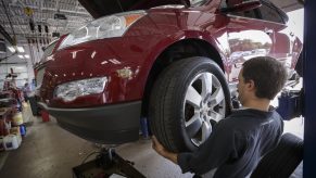 Technician Dave Serdar rotates the tires on a Chevy Traverse