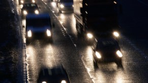 Headlights on oncoming vehicles traveling on a rain-slicked multi-lane highway