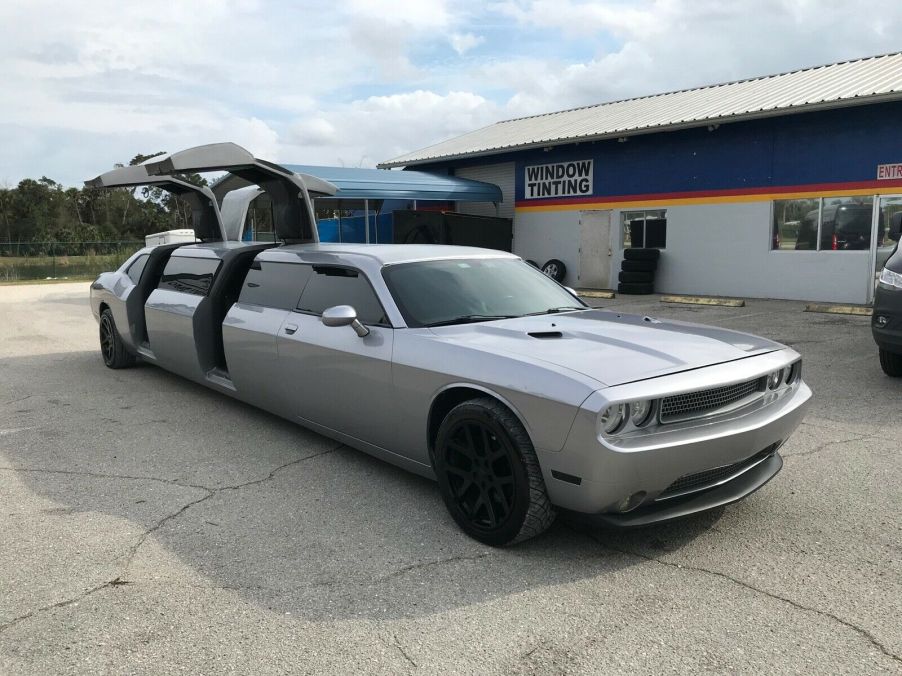 An image of a Dodge Challenger limousine outside with its doors open.