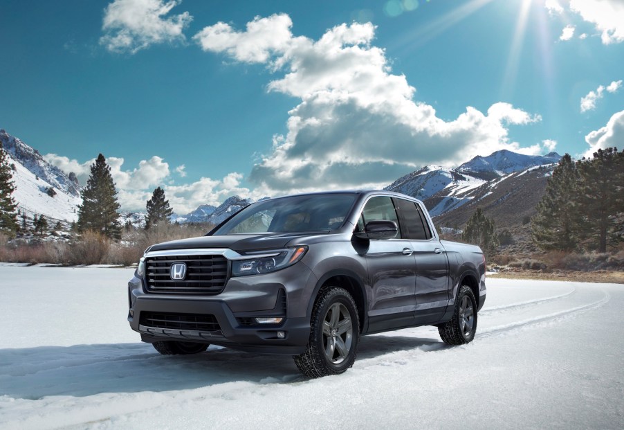 The 2021 Honda Ridgeline RTL-E parked in an open plain in front of trees.