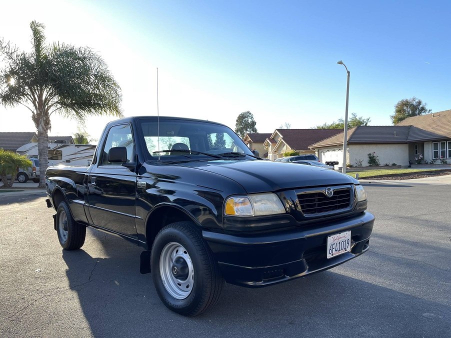 A black 2000 Mazda B3000 SX on a neighborhood street