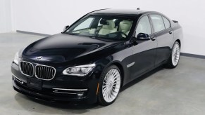 A dark-blue 2013 BMW Alpina B7 xDrive in a white warehouse