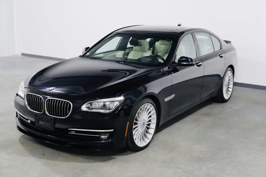 A dark-blue 2013 BMW Alpina B7 xDrive in a white warehouse